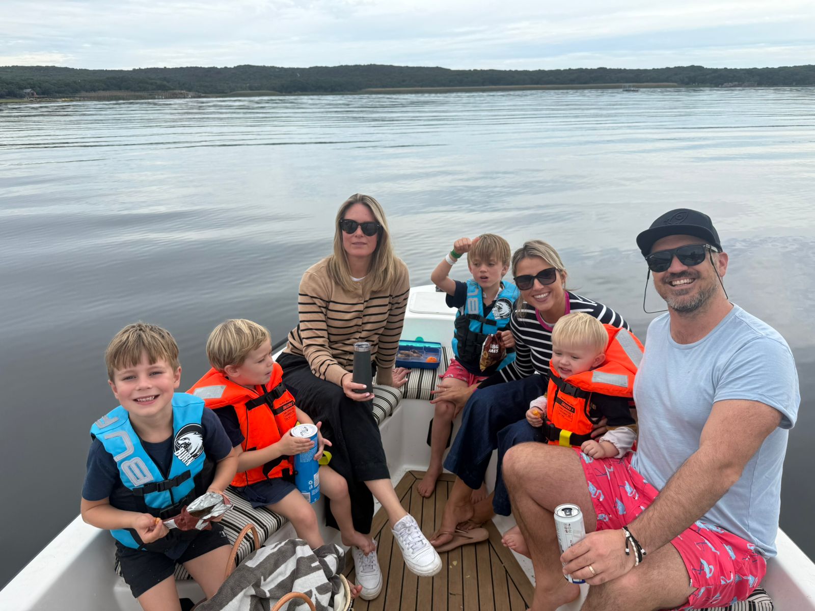 Extended family with young children sitting on a boat on the calm lagoon