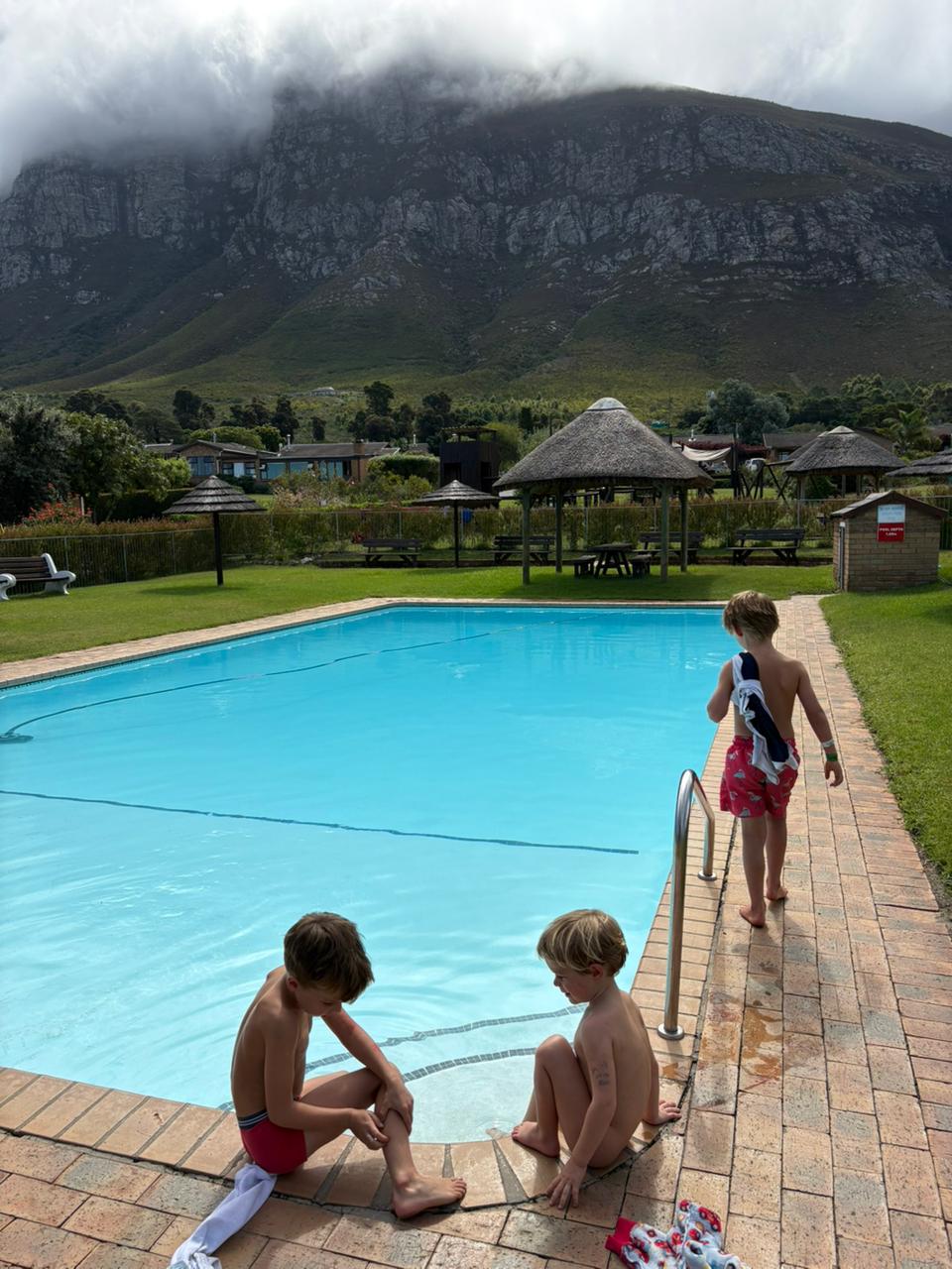 Children beside the estate swimming pool with the mountain behind