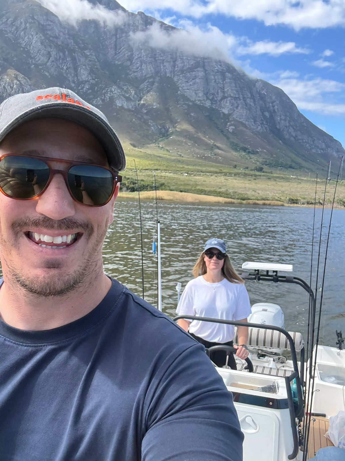 Couple on a fishing boat with the Hermanus mountain rising behind them
